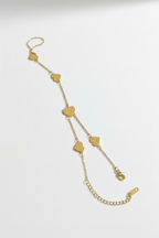 Gold chain necklace with heart-shaped pendants on a white background