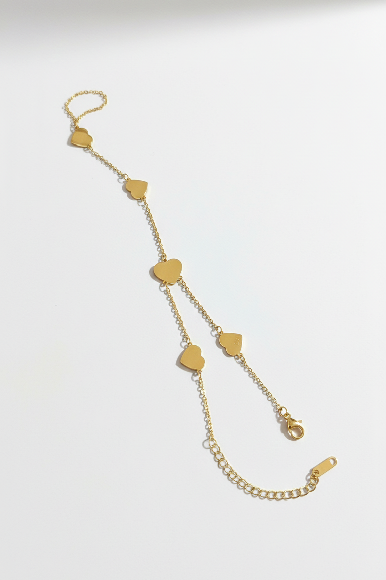 Gold chain necklace with heart-shaped pendants on a white background