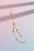 Gold bracelet with heart-shaped links on a gradient pink and blue background