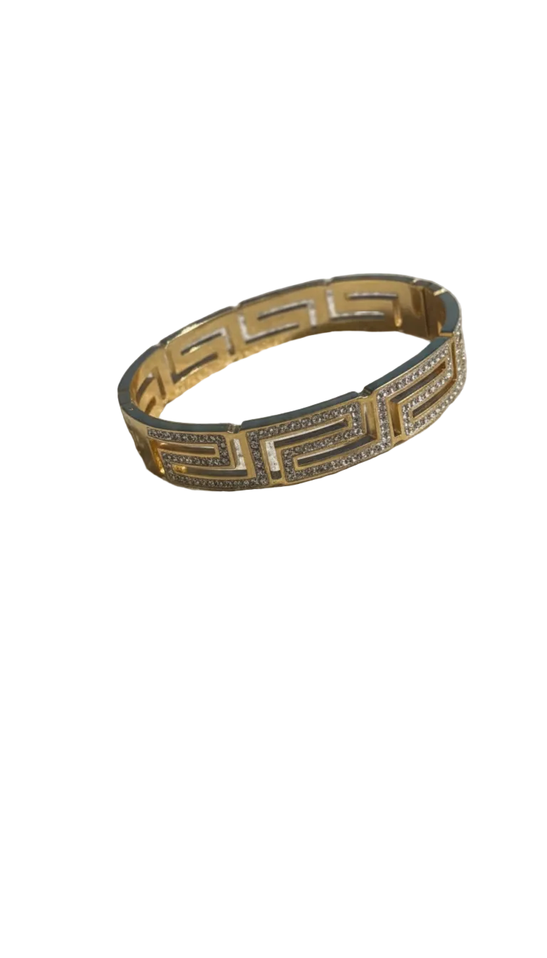 Gold bracelet on a sandy surface