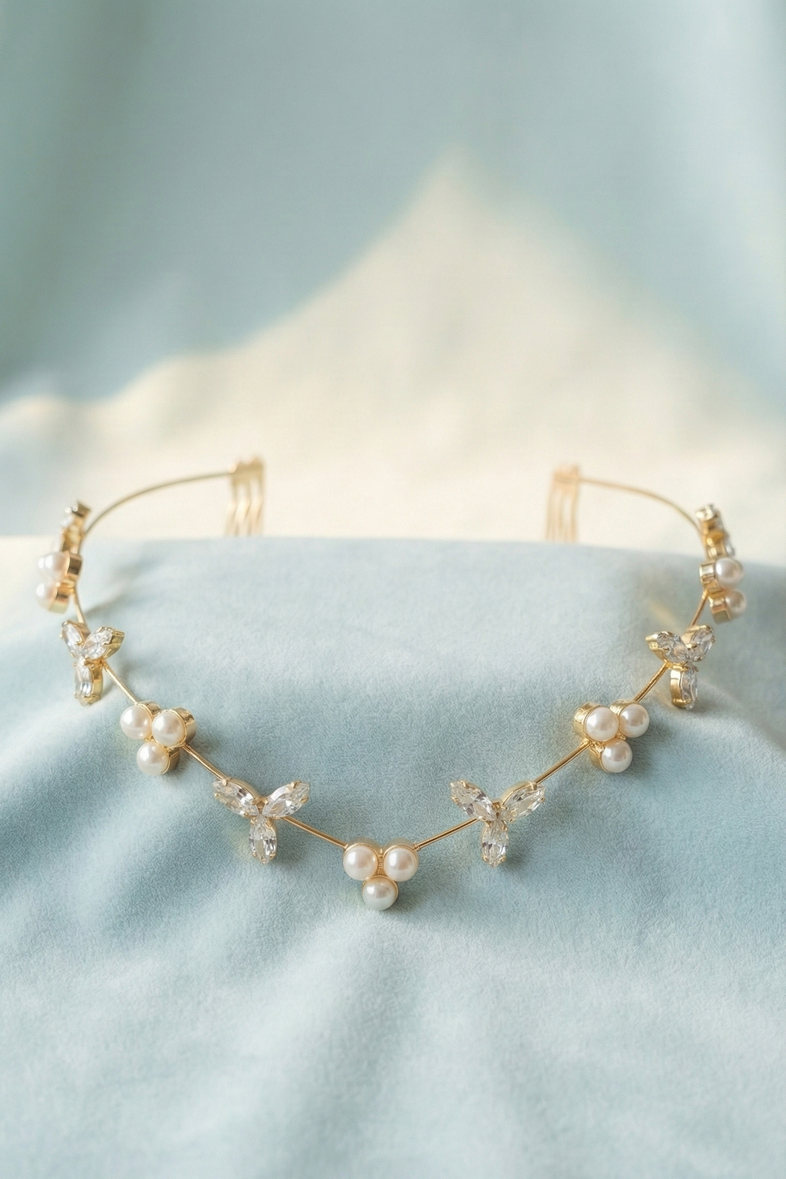 Gold headband with pearls on a light blue background