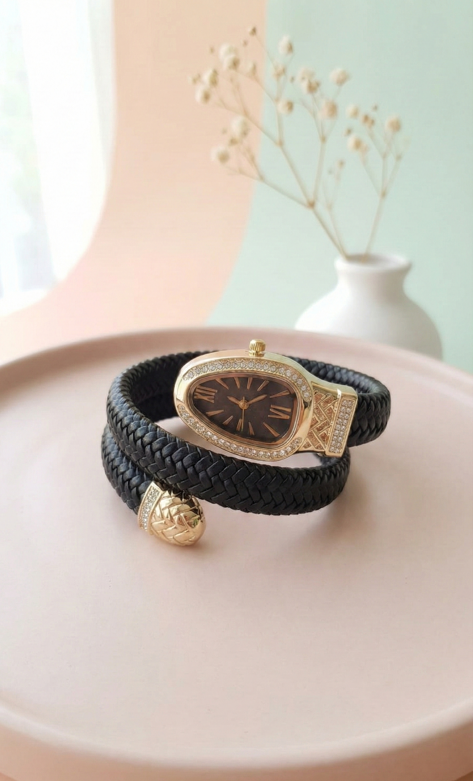 Black and gold bracelet on a white dish with a light green background