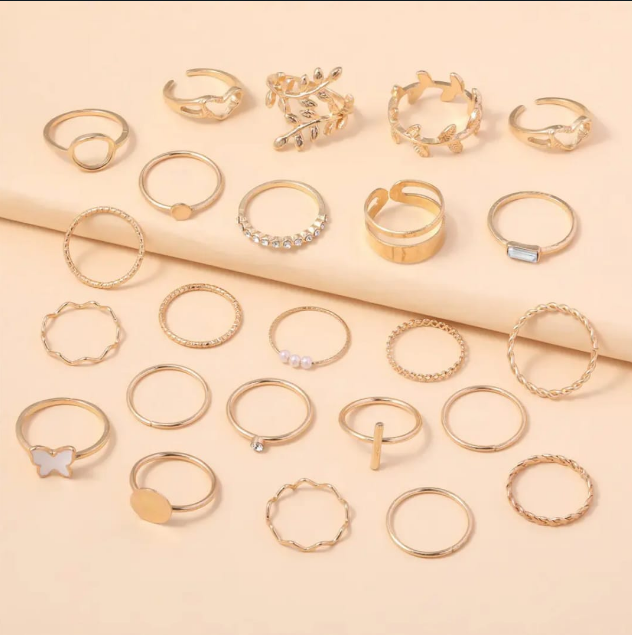 Collection of gold rings on a beige background