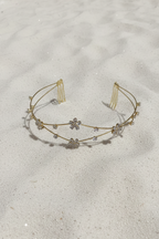 Gold headband with small decorative elements on a sandy background