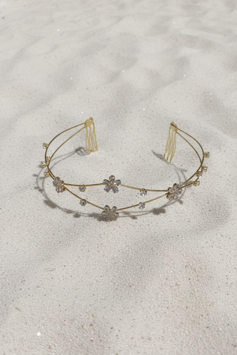 Gold headband with small decorative elements on a sandy background