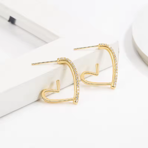 Small Gold-Tone Crystal-Accented Heart Earrings - ORYX TREND EaringThese stylish heart-shaped earrings are crafted in a bright gold tone and feature a partial row of shimmering clear stones along the top edge. The open-frame design keeps them lightweight and easy to wear. They are an ideal choice for adding a little sparkle and warmth to your look.Default Title#