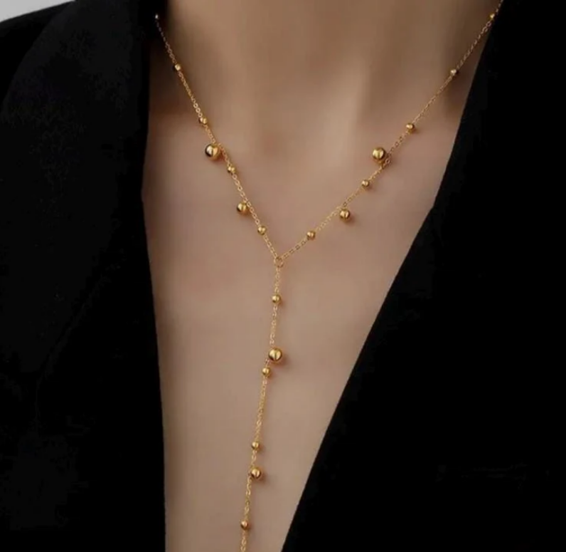 Gold necklace on a mannequin with a black background