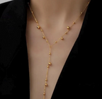 Gold necklace on a mannequin with a black background