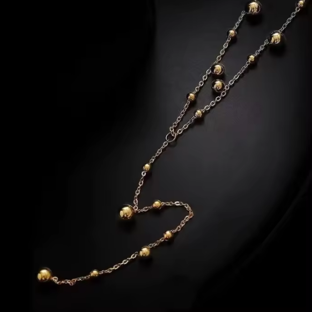 Gold and silver chain necklace on a dark background