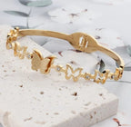 Dainty Gold Butterfly Cuff Bracelet with Crystal Accents - ORYX TREND BraceletsAn elegant gold-tone bangle bracelet featuring a central, intricately textured butterfly charm. The rest of the cuff is adorned with delicate cutout butterfly shapes, interspersed with small, sparkling crystal accents. This piece uses a durable, hinged clasp for secure and comfortable wear. It beautifully symbolizes transformation and grace, making it a perfect statement piece or a thoughtful gift.Default Title#