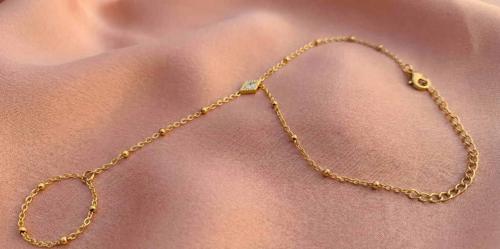 Diamond Shape Hand Harness Bracelet - ORYX TREND Hath PhoolThis delicate Hath Phool (Hand Flower) is a modern take on a classic piece of South Asian jewelry. Featuring a slim chain of polished gold beads connecting a single finger ring to an elegant bracelet, it's accented by a central diamond-shaped charm. This minimalist hand harness is perfect for bridesmaids, festivals, or adding a unique, elegant touch to everyday wear. Style: Hath Phool, Hand Harness, Minimalist, TraditionalDefault Title#