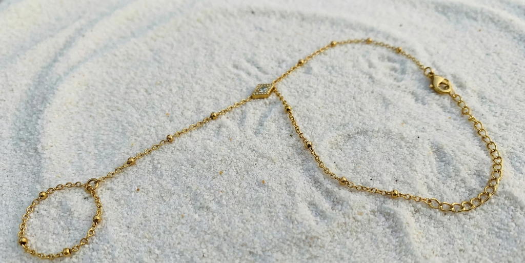 Diamond Shape Hand Harness Bracelet - ORYX TREND Hath PhoolThis delicate Hath Phool (Hand Flower) is a modern take on a classic piece of South Asian jewelry. Featuring a slim chain of polished gold beads connecting a single finger ring to an elegant bracelet, it's accented by a central diamond-shaped charm. This minimalist hand harness is perfect for bridesmaids, festivals, or adding a unique, elegant touch to everyday wear. Style: Hath Phool, Hand Harness, Minimalist, TraditionalDefault Title#