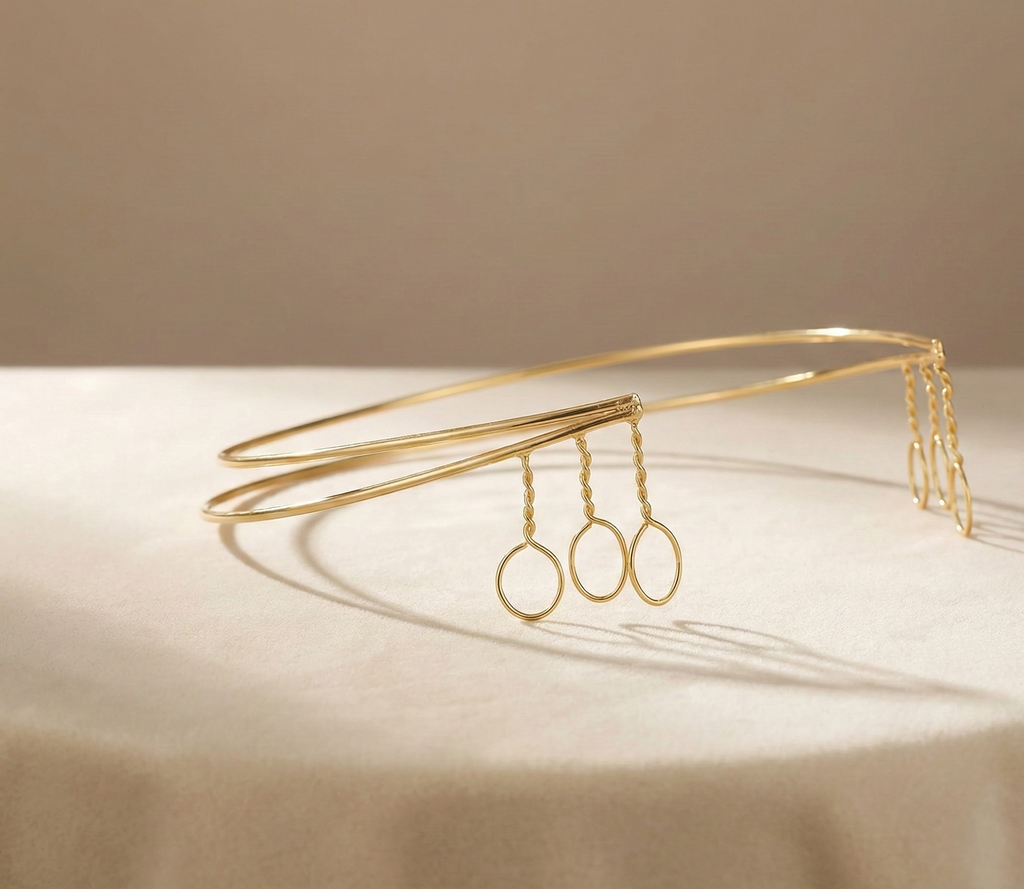 Gold headband with hanging loops on a beige background