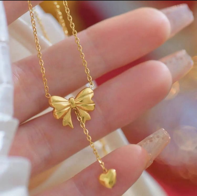 Elegant Gold Bow and Heart Pendant Necklace - ORYX TREND NecklaceFind your new go-to accessory with this beautiful gold bowknot necklace. The intricate bow detail leads to a suspended heart charm, creating a graceful, minimalist look. This piece is perfect for layering or wearing on its own for a subtle statement.Default Title#