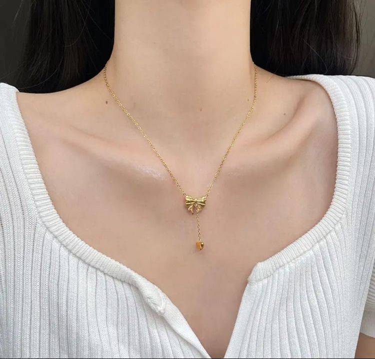 Elegant Gold Bow and Heart Pendant Necklace - ORYX TREND NecklaceFind your new go-to accessory with this beautiful gold bowknot necklace. The intricate bow detail leads to a suspended heart charm, creating a graceful, minimalist look. This piece is perfect for layering or wearing on its own for a subtle statement.Default Title#