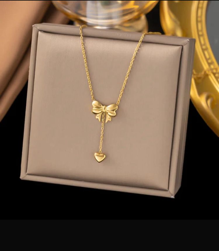 Elegant Gold Bow and Heart Pendant Necklace - ORYX TREND NecklaceFind your new go-to accessory with this beautiful gold bowknot necklace. The intricate bow detail leads to a suspended heart charm, creating a graceful, minimalist look. This piece is perfect for layering or wearing on its own for a subtle statement.Default Title#