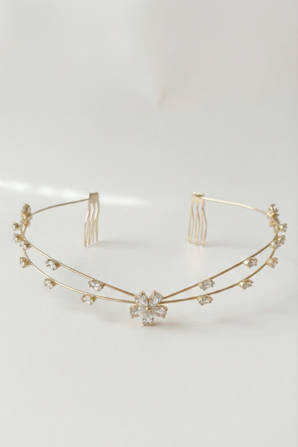 Gold headband with floral design on a light gray background