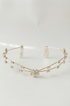 Gold headband with floral design on a light gray background