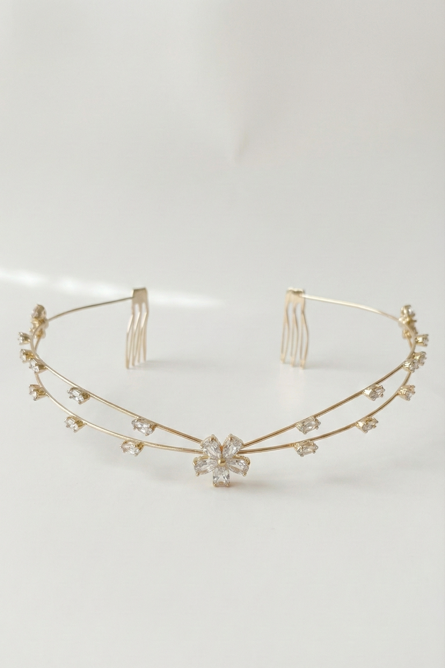 Gold headband with floral design on a light gray background