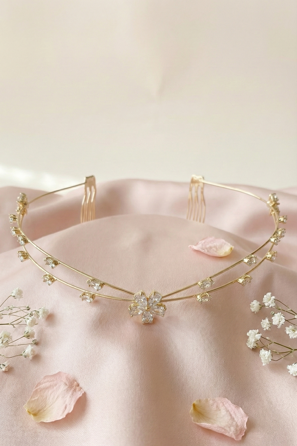 Gold necklace with floral elements on a pink fabric background