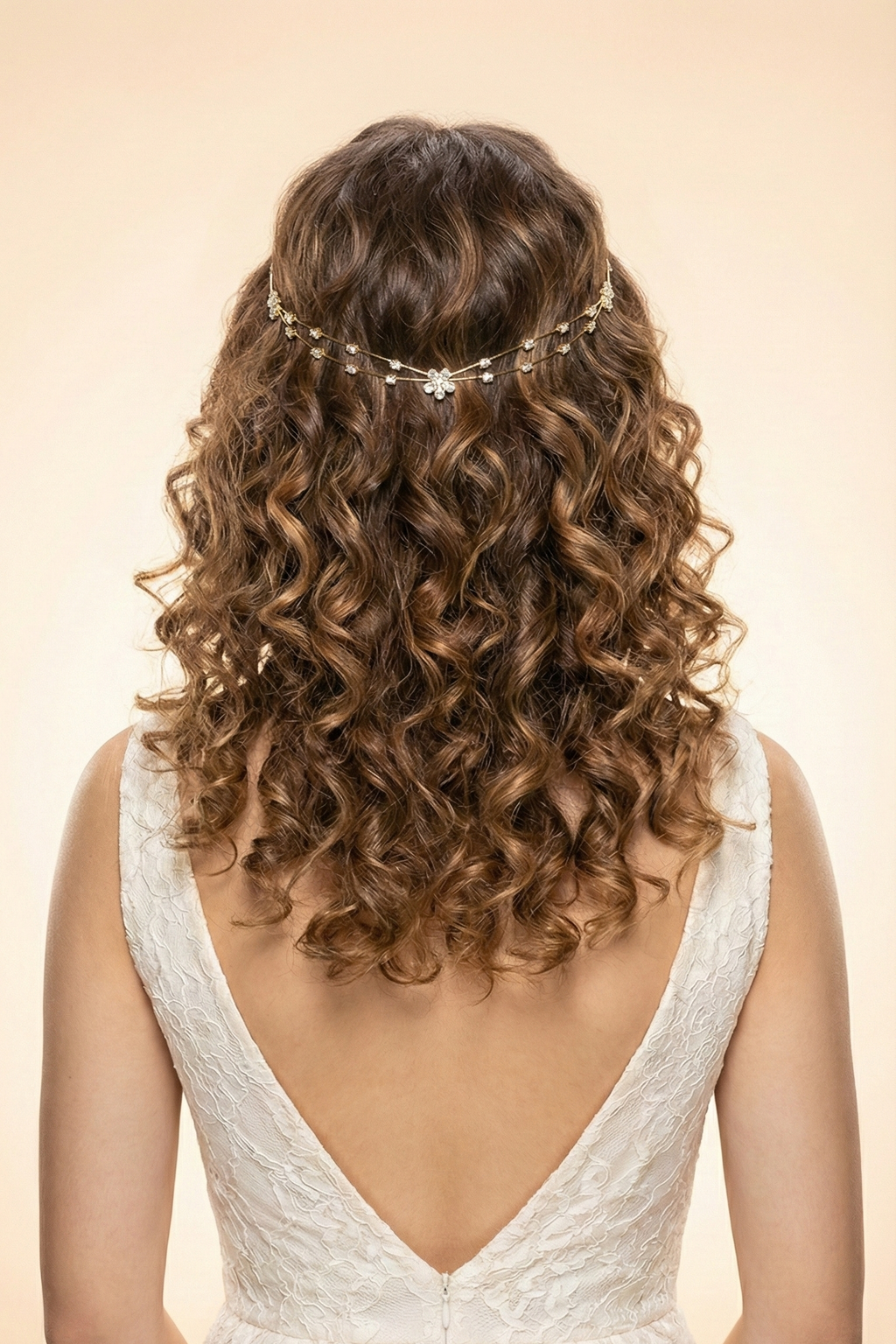 Woman with curly hair wearing a delicate headpiece, back view, on a beige background