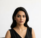 Woman in a black dress sitting on a chair against a white background