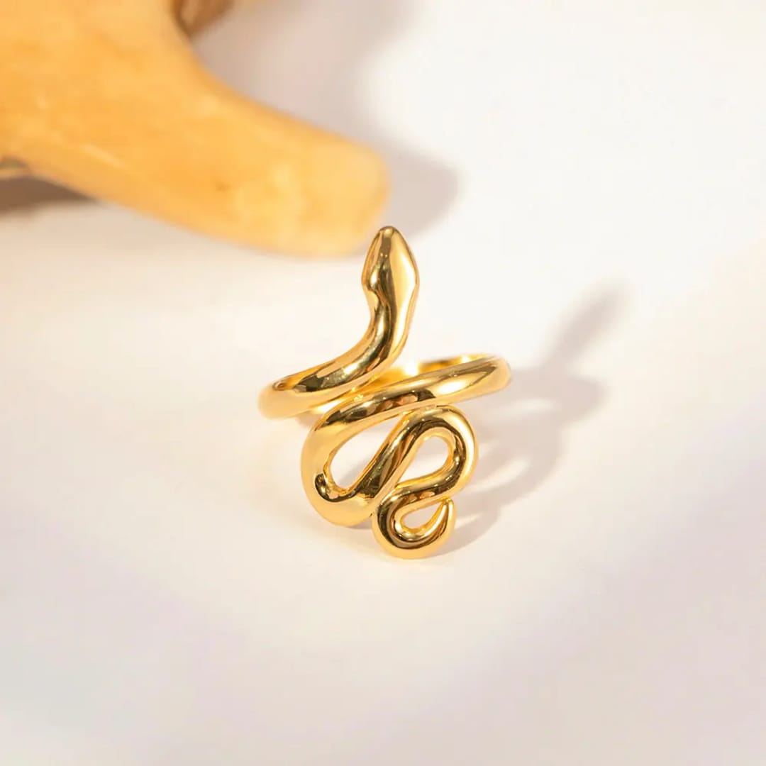 Gold snake-shaped ring on a light background
