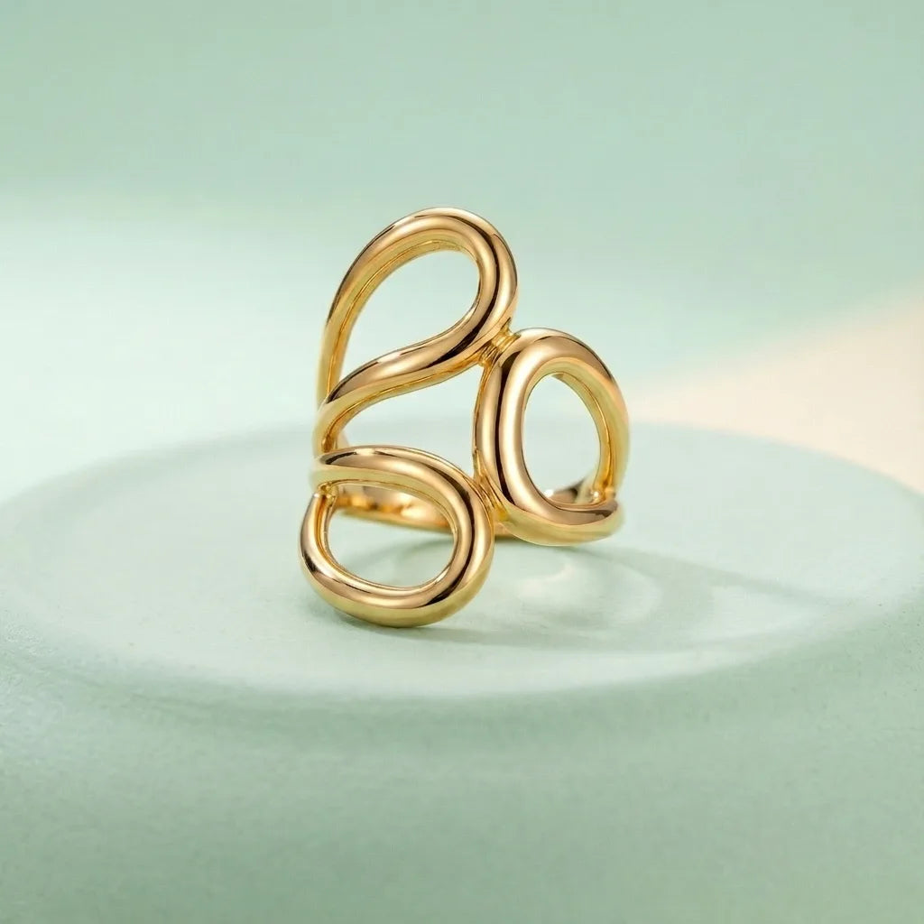 Gold Statement Knot Ring - Modern Minimalist Jewelry - ORYX TREND RingElevate your style with the ORYX trend Gold Statement Knot Ring. This piece features a captivating modern, abstract loop design that makes a bold yet elegant statement. Crafted with high-quality, polished gold-tone metal, this adjustable ring is perfect for the minimalist fashion enthusiast looking for an eye-catching accessory. Ideal for stacking or wearing solo. Shop the best in contemporary gold Plated jewelry from ORYX trend.#
