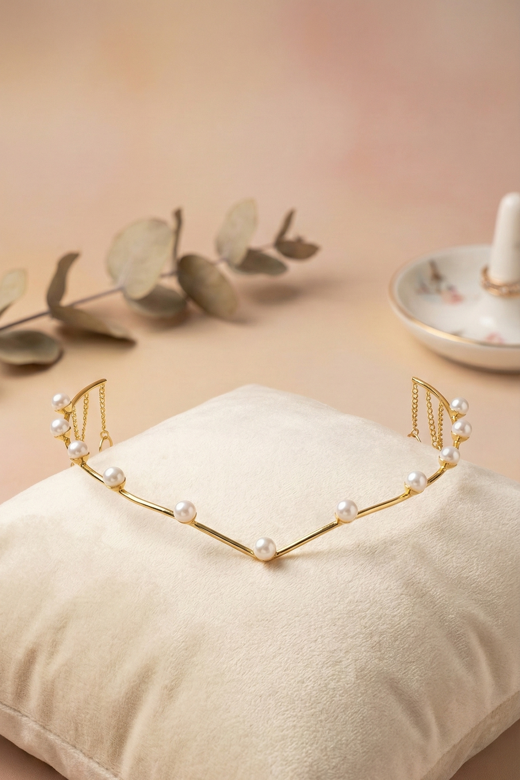 Gold headband with pearls on a beige pillow