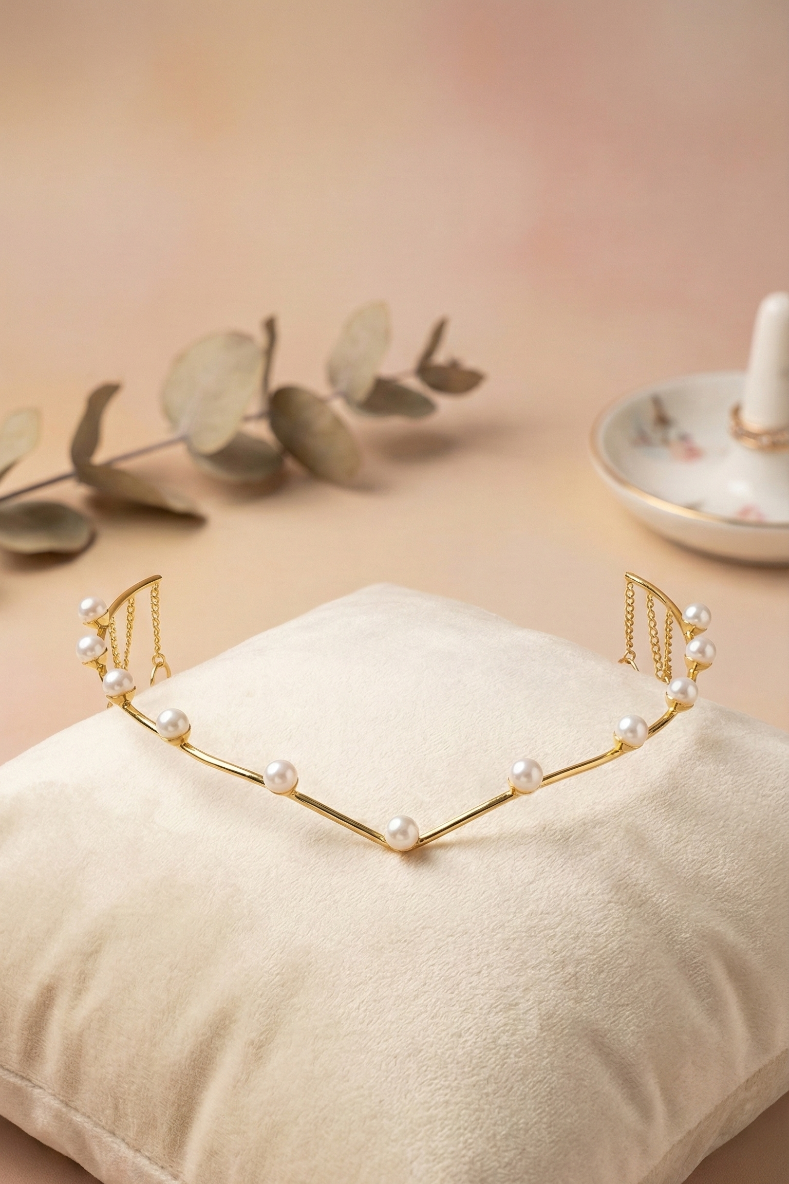 Gold headband with pearls on a beige pillow