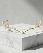 Top: Jewelry box with pearls, middle: Floral crown on a stone surface, bottom: Gold crown on a marble stand.