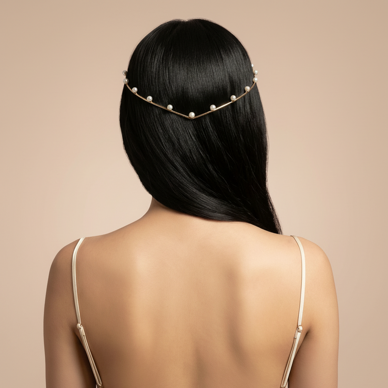 Woman wearing a pearl hair accessory with a plain background
