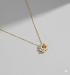 Interlocking Hearts Gold-Tone Necklace with Crystal Pavé - ORYX TREND NecklaceA delicate and sentimental necklace featuring two beautifully interlocking rings. One ring is a heart shape completely adorned with sparkling crystal pavé stones, while the other is a smooth, polished ring. This design symbolizes infinite love and unbreakable connection. The pendant is suspended from a fine, gold-tone chain, making it an ideal gift for an anniversary, Valentine's Day, or just to show someone you careDefault Title#