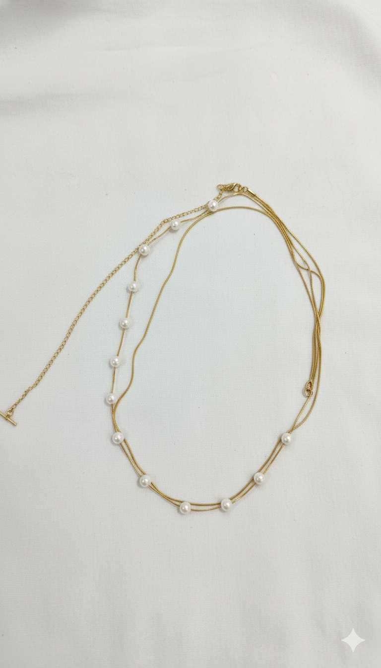 Gold necklace with pearls on a light gray background
