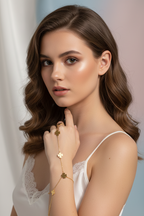 Woman wearing a white lace top with gold jewelry against a neutral background