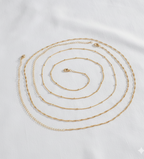 Set of gold necklaces on a light gray background