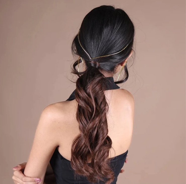 Woman with styled hair in a ponytail against a beige background