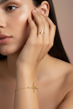 Woman wearing gold jewelry on a neutral background