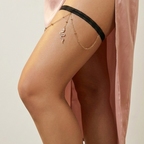 Leg wearing sheer stockings with a black band and a pink satin skirt.