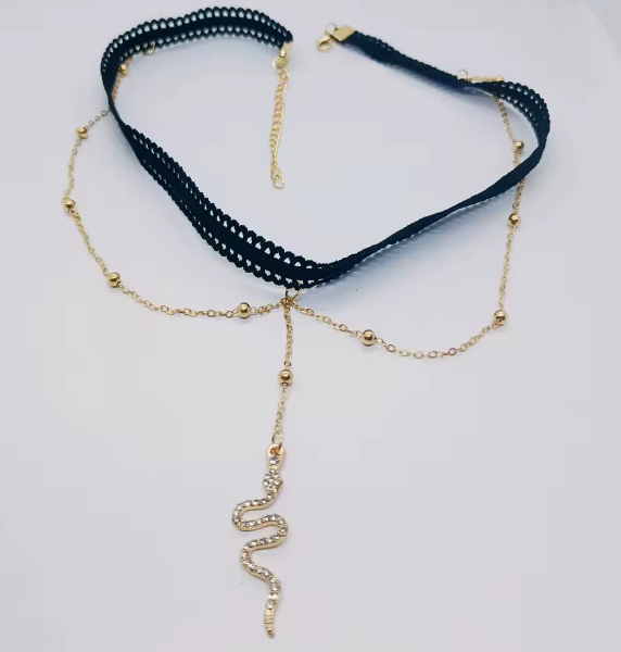 Gold necklace with a blue ribbon on a light gray background