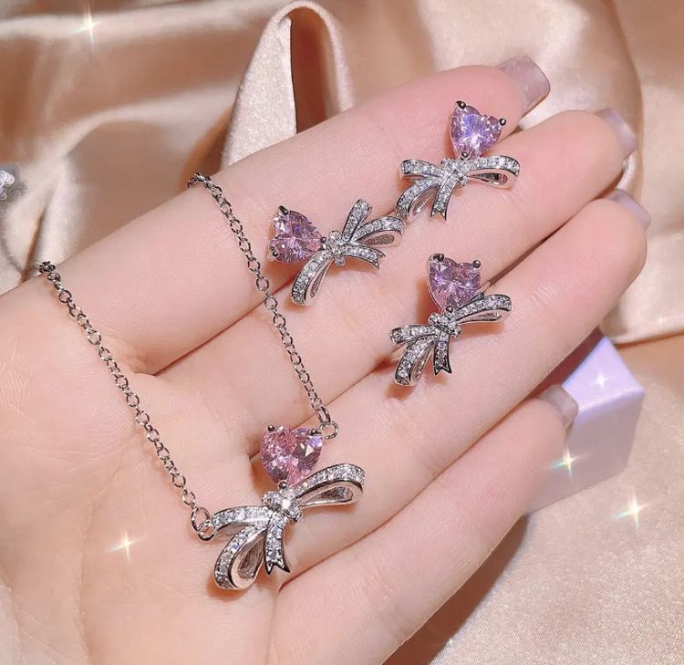 Silver-Plated Cubic Zirconia Bow and Heart Necklace and Earring Set - ORYX TREND NecklaceElevate your style with our charming pink heart and bow jewelry set. This beautiful necklace and earring set is adorned with sparkling rhinestones and a cubic zirconia heart, making it an ideal accessory for any outfit. It's a perfect gift for someone special.Default Title#