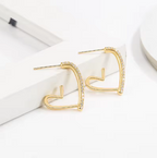 Small Gold-Tone Crystal-Accented Heart Earrings - ORYX TREND EaringThese stylish heart-shaped earrings are crafted in a bright gold tone and feature a partial row of shimmering clear stones along the top edge. The open-frame design keeps them lightweight and easy to wear. They are an ideal choice for adding a little sparkle and warmth to your look.Default Title#
