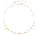 Gold necklace with star-shaped pendants on a white fabric background