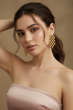 Woman wearing gold hoop earrings against a beige background