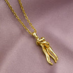 The Embrace Necklace: Gold-Tone Hug Pendant - ORYX TREND NecklaceA beautifully artistic necklace featuring a minimalist pendant design that captures the tender moment of an intimate embrace. The gold-tone pendant depicts two stylized figures locked in a hug, symbolizing love, connection, comfort, and friendship. Suspended from a delicate gold-toned chain (perhaps a flat link or paperclip style), this unique piece makes a deeply personal and meaningful gift for a loved one.Default Title#