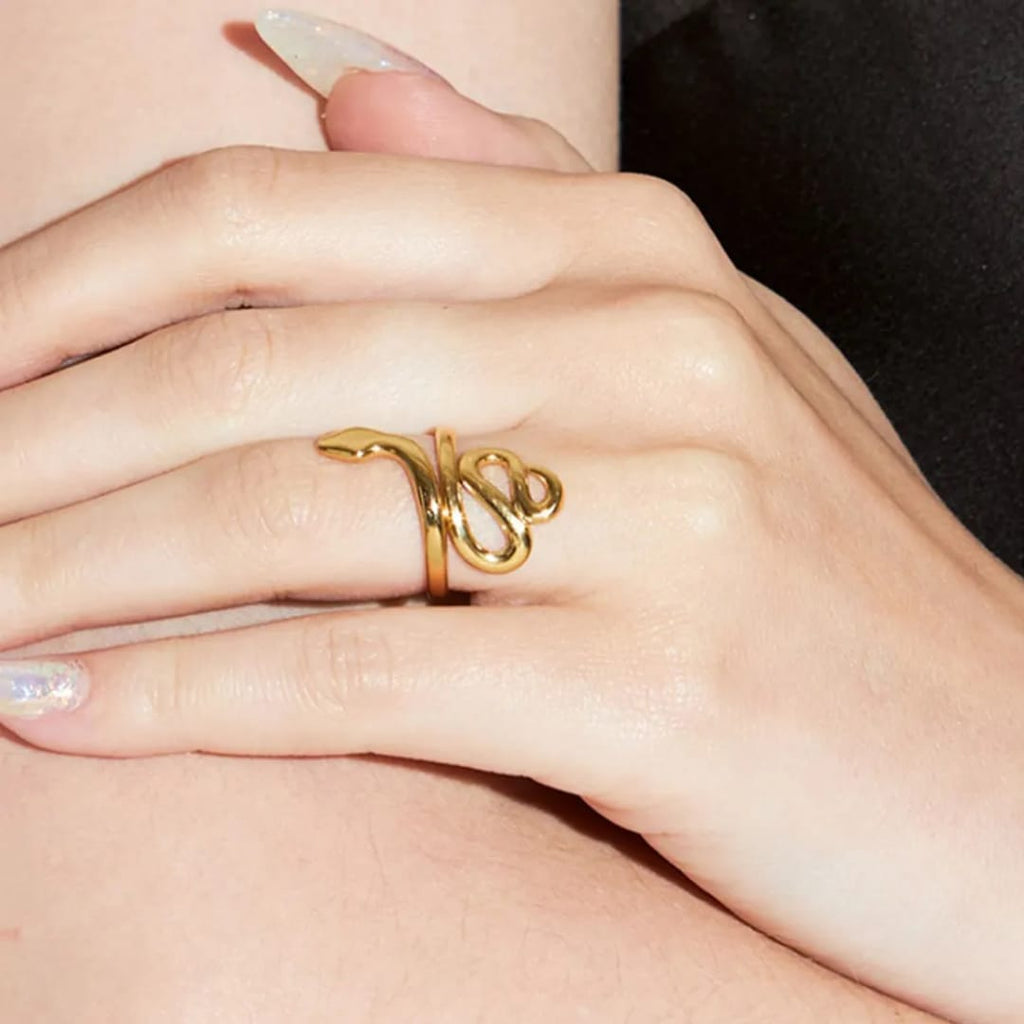 Gold ring on a person's finger with a plain background